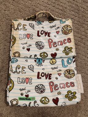 This SugarBooger brand lunch bag features a vibrant "Peace & Love" doodle patter